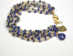 Six strands of lapis lazuli. 18kt gold plate over sterling silver. 6 3/4 inch fit length with 1 inch extender chain. Gold Lapis Lazuli Bracelets For Gift, Gold Bracelets With Lapis Lazuli And Natural Stones, Gold Lapis Lazuli Bracelet With Gemstone, Gold Lapis Lazuli Gemstone Bracelet, Gold Lapis Lazuli Spiritual Bracelets, Artisanal Design, Lapis Lazuli Bracelet, Smoky Topaz, Stone Wrapping