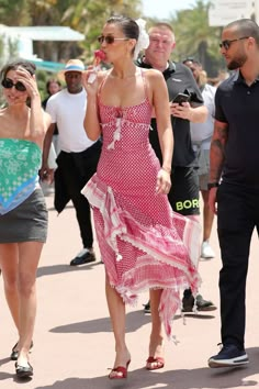 a woman in a pink dress walking down the street