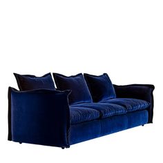 a blue velvet sofa with four pillows on it's back and two side facing each other