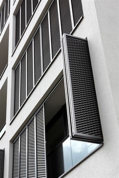 an apartment building with black and white shutters on the windows is seen in this image