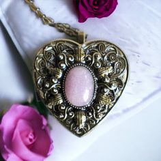 "Rose quartz music box pendant. This heart shaped music box pendant is inspired by the gorgeous music box pendants of era's gone by. Music box is pill box size, please look at the dimensions for exact size.  A perfect bronze heart locket has been adorned with a layer of filigree and an oval rose quartz stone. The stone is set in a bronze bezel. The filigree and bronze bezel have been finished with resin to preserve the beauty of this pendant. The music box winds from a key on the back of the pendant. The pendant hangs from a 30\" bronze chain with a dragonfly toggle clasp. The locket opens and closes by pushing the little button on the side and reveals a tiny working music box that plays an 18 note musical tune.  Choose the music box tune you would like at checkout.To listen to the music b Elegant Vintage Heart Pendant Jewelry, Victorian Jewelry For Valentine's Day Keepsake, Victorian Keepsake Jewelry For Valentine's Day, Victorian Locket Necklace With Vintage Charm For Valentine's Day, Vintage Heart Necklace For Memorial, Victorian Pendant Locket Necklace For Valentine's Day, Vintage Pink Jewelry For Keepsake, Elegant Heart Locket Necklace Collectible, Antique Rose Gold Heart Jewelry