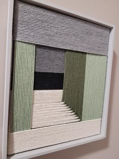 an art piece hanging on the wall with different colors and shapes in it's frame