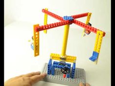 a person is playing with legos on a white table and holding it up to the camera