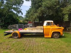 an orange truck is parked in the grass