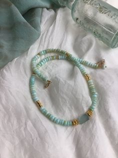 "This aqua gold gemstone choker has Peruvian Opal and Aquamarine beads with Bali gold beads. The Peruvian Opals are rondelle shapes. The aquamarine focal bead has an organic shape a matte finish. The 24k gold beads are from Bali. It is 14\" with a 2\" extender and gold filled lobster claw clasp." Opal Beads Necklace, Gold Single Strand Amazonite Beaded Necklace, Gold Single Strand Beaded Necklace With Amazonite, Turquoise Aquamarine Round Bead Necklaces, Aquamarine Necklaces With Round Beads Of Natural Stones, Aquamarine Necklace With Natural Round Beads, Aquamarine Necklace With Round Natural Stone Beads, Aquamarine Necklace With Round Natural Stones, Adjustable Light Blue Gemstone Beaded Necklace