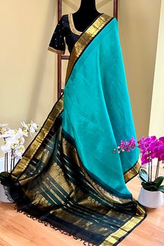 This regal korvai silk cotton saree is in copper sulphate blue with black border and pallu is handwoven. The saree borders are adorned with traditional motifs in gold zari. The black pallu is grand with a rich gold zari work. Approximate Length 6.5 mtrs (inclusive of blouse length)Height - 48 - 52" Saree comes with fall, picot and tassels done when applicable. Blouse piece is cut. Approximate weight - 1.3 lbs Kindly Note : The colors you see on your device may vary due to the color reproduction, Saree Border, Blue Saree, Silk Cotton Sarees, Readymade Blouse, Blouse Length, Blouse Piece, Cotton Saree, Victorian Dress, Hand Weaving