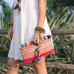 "This beautiful crossbody bag is made with an amazing piece of fabric woven by the HMONG hill tribes of Lanna Country (Northern Thailand). It decorate with multi pom pom. It features a zippered opening area, inside zippered pocket and removable strap. It's a great bag for carrying anything. We buy materials from Hmong market and we design and sew by hand. Some of the bags we modify to improve the product. The Hmong tribes live in the North of Thailand and have origins from the Tibetan area of Ch Bohemian Fabric Travel Bag, Bohemian Travel Bags In Fabric, Bohemian Fabric Tote Bag, Bohemian Fabric Bag With Rectangular Shape, Bohemian Fabric Bags With Rectangular Shape, Bohemian Fabric Rectangular Bag, Bohemian Rectangular Fabric Bag, Bohemian Multicolor Fabric Bag, Traditional Summer Pouch Shoulder Bag