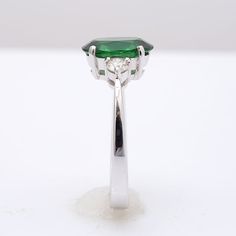 This oval cut Tsavorite Garnet, set at the center of this ring steals the show. It’s rich green, has been highlighted by the perfectly matched round brilliant diamonds that rest on either side of the center stone. Eye clean and large in size, this 2.13 carat stone is a rare gem. Set in 18K white gold, this ring is just the right combination grace and beauty. Order online info@jupitergem.com Tsavorite Garnet, Detailed Ring, Rare Gems, Rich Green, White Gold Ring, Diamond Sizes, Vibrant Green, Brilliant Diamond, Sparkle Diamonds