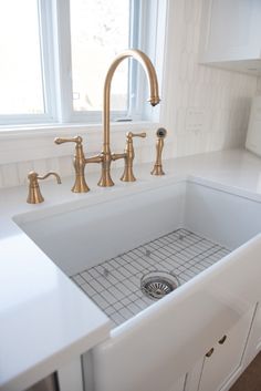 a kitchen sink with two faucets and a window