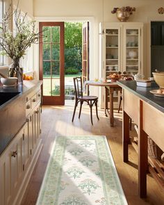 a kitchen with an area rug in front of the counter and door leading to another room