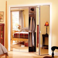 a bedroom with mirrored closet doors in it