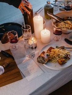 the table is set with food, wine and candles for an intimate dinner or celebration