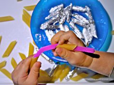 a person holding a pink toothbrush in front of a blue plate with silver foil on it