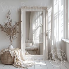 a large white framed mirror sitting on top of a floor next to a basket filled with flowers