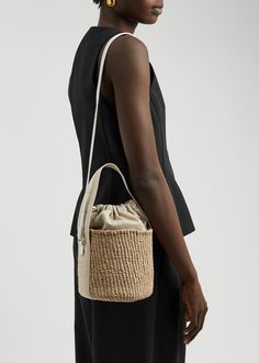 Find CHLOÉ Chloé Raffia Bucket Bag on Editorialist. The Chloé raffia bucket bag is crafted from woven raffia and features a canvas top handle, leather shoulder strap, canvas panels with metallic logo embroidery, logo-debossed leather base, and an internal leather patch pocket. The bag is fully lined and has a drawstring fastening top. It measures 5.5 inches in width, 6.5 inches in height, and 5.5 inches in depth. The top handle drop is 6 inches and the shoulder strap drop is 18 inches. Beige Bucket Bag With Intrecciato Weave, Luxury Beige Bucket Bag With Intrecciato Weave, Evening Beige Bucket Bag With Braided Handles, Luxury Bucket Bag With Intrecciato Weave, Luxury Woven Leather Bucket Bag, Elegant Bucket Bag With Intrecciato Weave, Natural Bucket Bag With Intrecciato Weave, Bucket Pouch Bag With Braided Handles For Errands, Daily Use Bucket Bag With Intrecciato Weave