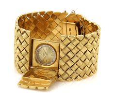 This is a stunning Retro Era wide watch bracelet, it is crafted from solid 18k yellow gold with a polished textured finish. It is wide and has a rectangular shape open and close cover for a small round Universal Geneve hand winding watch. There are small groove design box shape links fitted together in a symmetrical to form a 1.25 inches wide band, it fastens with a push in clasp with chain attach and latch for added security. Material: 18k yellow gold     Hallmark: Made Italy 18k Measurement: Universal Geneve, Design Box, Fancy Design, Retro Era, Design Bracelet, Gold Feathers, Heart And Key, Circle Diamond, Watch Bracelet