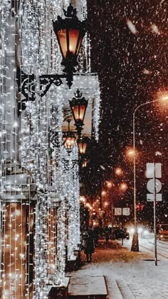 a street light covered in snow next to a building with lots of lights on it