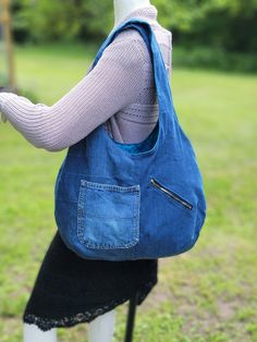 Large, soft, lined denim hobo bag with 3 pockets and nice wide straps.  This large bag is made with upcycled denim and is lined with a cotton fabric in a teal color with small black flowers on it.  There is one large zippered pocket on the inside, along with a hoop to hook your keys onto.  There are two pockets on the outside, one of which is a large zippered pocket.  The straps are 25 inches long and the bag is 20 inches wide by 15 inches deep (all measurements are approximate). Cheap Denim Blue Hobo Bag For Daily Use, Cheap Denim Blue Hobo Bag For Women, Hobo Bag From Old Jeans Free Pattern, Cheap Blue Hobo Bag With Pockets, Cheap Casual Denim Hobo Bag, Cheap Blue Denim Hobo Bag, Cheap Blue Hobo Bag With Handles, Cheap Denim Hobo Tote Bag, Denim Hobo Bag