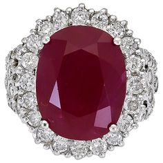 Featuring a 17.94 carat cushion cut vibrant red ruby, accented by a halo of round brilliant diamonds. Set on a chic split shank setting set with more diamonds. Made in 18k white gold. Ruby weighs 17.94 carats Diamonds weigh 2.17 carats total Size 6 US (sizable) Dimensions: 0.91 in x 0.78 in. Antique Cushion Cut Diamond, Contemporary Engagement Rings, Diamond Halo Engagement Ring, Modern Engagement Rings, Diamond Cocktail Rings, Red Diamond, Stone Engagement Rings, Engagement Ring Styles, Halo Diamond Engagement Ring