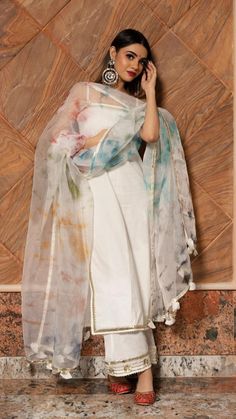 Make an everlasting, eternal impression at any upcoming festive occasion in this white cotton suit set with beautiful multi color dupatta comparising with beautiful gotta lace boarder.The suit set features an overall gotta patti lace work,The multi color organza dupatta comes with an gotta lace border and tassel detailing around the edges. This is a great pick for the festive season! SKU#: 11403157WH Disclaimer: There may be slight difference in actual product color compared to product images. Suits For Women Indian, डिजाइनर कपड़े, Indian Dresses For Women, Organza Suits, Trendy Outfits Indian, Fancy Sarees Party Wear, Casual Indian Fashion, Desi Fashion Casual, White Suit