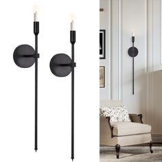 a pair of black sconces with two candles on them and a chair in the background