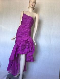 Vtg late 80s Victor Costa stunning Purple ruched asymmetrical bodycon ball gown 8S Preowned. Condition. 10/10. No issues. No signs of wear. A stunning couture ball gown or special occasion dress. Purple acetate, rear zipper, fully lined, this dress is a masterpiece of engineering. Extensive ruching in the boned figure hugging bodice, swathes of extra fabric gather falls from the diagonal waist one side accentuating the hip with a huge fabric rosette, bow and on the other side, an asymmetrical cu Cocktail Gown With Ruched Fitted Bodice, Asymmetrical Party Evening Dress With Ruched Bodice, Asymmetrical Evening Dress With Ruched Bodice For Party, Fitted Ruched Evening Dress, One Shoulder Ruched Fitted Gown, Fitted Ruched Evening Dress For Party Season, Fitted Asymmetrical Prom Evening Dress, Fitted Ruched Evening Gown, Fitted Asymmetrical Pre-draped Evening Dress