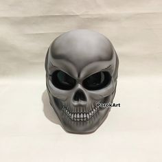 a gray skull mask with black eyes on a white background