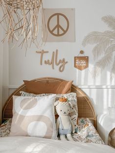 there is a teddy bear on the bed in this room with peace sign above it