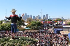 a large crowd is gathered around a man in a cowboy hat on top of a hill