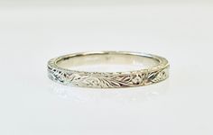 a white gold wedding ring with leaves on it