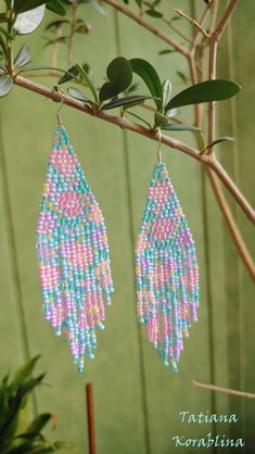 two pairs of beaded earrings hanging from a tree branch