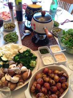 a table filled with different types of food and wine glasses on top of the table