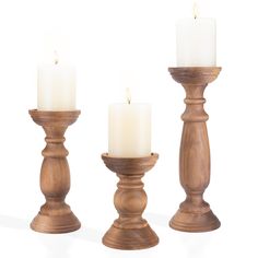 three wooden candlesticks with one candle lit