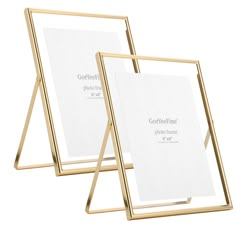 two gold metal frames with white paper on them