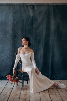 a woman in a white dress sitting on a chair