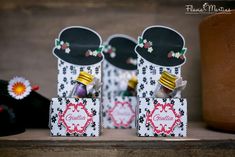 three small boxes with hats on them sitting on a table next to other items and decorations