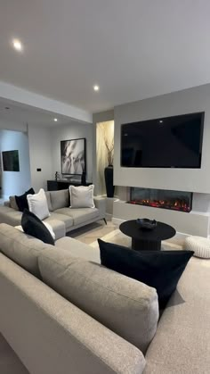 a large living room with couches and a flat screen tv mounted on the wall