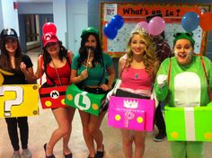 four women dressed up in costumes posing for the camera with balloons and question marks on them