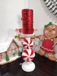 a gingerbread christmas cake on a table next to a candy cane and candle holder