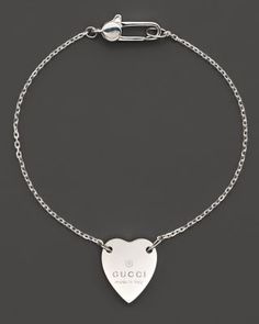 From the Trademark Collection, this sweet sterling silver bracelet features a woven chain with engraved logo heart charm. Designed by Gucci. Classic Bracelets With Logo Charm As A Gift, Luxury Sterling Silver Bracelets For Valentine's Day, Sterling Silver Heart Bracelet Fine Jewelry, Sterling Silver Heart-shaped Fine Bracelets, Sterling Silver Heart Bracelets Fine Jewelry, Heart-shaped Sterling Silver Bracelets, Silver Bracelets With Logo Charm For Gift, Silver Bracelets With Logo Charm As Gift, Silver Charm Bracelet With Logo For Gift