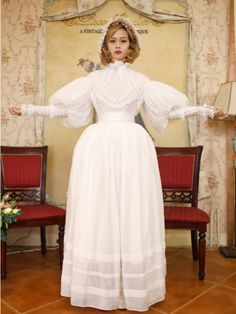 This price includes a blouse, a skirt, and a sash.  This set has a Victorian-era day dress inspiration. Dress / Top Details:Lace TrimNeckline:High Neck / Ruffle NecklineSkirt Details:Flounce Hem Skirt / LinedSleeves:Leg-of-Mutton Sleeves This is the size chart for the blouse.   	 		 			Size 			XS 			S 			M 			L 			XL 		 		 			Bust 			82 			86 			90 			94 			98 		 		 			Waist 			64 			68 			72 			76 			80 		 		 			Sleeve Length 			58 			58 			60 			60 			62 		 		 			Full Length 			58 			58 			60 Historical Design Vintage Dress For Costume, Elegant White Skirt For Costume Party, Historical Design Prairie Dress For Wedding, Wedding Prairie Dress With Historical Design, Victorian Style Vintage Dress For Costume, Victorian Vintage Dress For Costume, Victorian Style Long Sleeve Prairie Dress For Daywear, Victorian Prairie Dress With Long Sleeves For Daywear, Vintage Dress With Historical Design For Formal Occasions