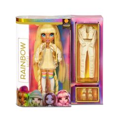 the doll is in its box and it has two outfits on top of it,