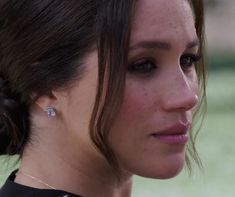 a close up of a person with a cell phone in her hand and earring