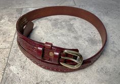 Ranger Style Western tooled leather belt, hand made by Bianchi for Eddie Bauer, solid brass buckle. Maroon color. Vintage/Pre-owned. Width: main strap 1 3/16", narrow strap 11/16". 1/8" thick. Length: from base of buckle to tip is 36". Length: from base of buckle to #3 (middle) hole is 31 1/4" (size 31 belt).  https://belts.com/how-to-measure-your-belt-size/ Formal Adjustable Belt With Brass Hardware, Adjustable Formal Belt With Brass Hardware, Vintage Adjustable Belts For Formal Wear, Vintage Leather Strap Belt For Everyday Use, Vintage Bridle Leather Belt For Everyday Use, Vintage Belts With Brass Buckle For Everyday Use, Vintage Bridle Leather Belt With Antique Buckle, Vintage Adjustable Belt With Leather Strap, Vintage Adjustable Leather Strap Belt