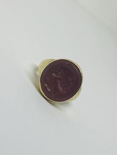 "This is a vintage 18K (high-karat) yellow gold Cameo-design statement ring. Definition of a \"cameo\": a piece of jewelry, typically oval in shape, consisting of a portrait in profile carved in relief on a background of a different color. Material(s): 18K yellow gold + unidentified material (cameo) Total weight: 12.2 grams Flaws (if any): None to mention Marking(s): \"18ct\" (translating to 18K gold) Measurements: The face of the ring measures 17.9 millimeters in height by 5.8 millimeters in wi Heirloom Yellow Gold Engraved Ring With Cabochon, Yellow Gold Cabochon Signet Ring For Wedding, Vintage Round Signet Ring For Formal Occasions, Luxury Cameo Ring As Gift, Elegant Brown Signet Ring For Formal Occasion, Classic Brown Engraved Jewelry, Classic Round Signet Ring With Intaglio, Formal Gold Cabochon Signet Ring, Vintage Engraved Cabochon Ring For Formal Occasions