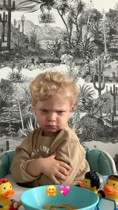 a little boy sitting in a high chair with his arms crossed