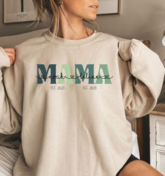 Celebrate motherhood with our Personalized MAMA Hoodie, customized with your children's names and their birth years for a truly special touch. This cozy MOM sweater makes a thoughtful and heartfelt gift for expectant mothers, baby showers, or as a memorable Mother's Day tribute. ♥PRODUCTION TIME: 1-5 days (usually 2-3 days) ♥SHIPPING TIME: 2-5 days (usually 3 days) ♥PRODUCT DESCRIPTION: Gildan Crewneck Unisex Sweatshirt Super soft cotton and excellent quality print makes. 50% cotton and 50% polyester (fibre content may vary for different colors) Medium-heavy fabric (8.0 oz/yd² (271.25 g/m²) Runs true to size Our Relaxed Fit Sweatshirt (Gildan 18000) is a unisex style that runs a touch small for men, and about a half a size large for women. It's a relaxed fit and is soft and cozy. * For Swe Mother's Day Lettering Crew Neck Sweatshirt, Cute Mother's Day Crew Neck T-shirt, Mama Shirts Sweatshirts & Hoodies, Mother's Day Crew Neck T-shirt With Screen Print, Personalized Mother's Day Crew Neck T-shirt, Mama Hoodie, Mama Sweater, Mom Sweater, Workout Sweatshirt