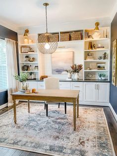 a dining room table and chairs in front of a bookcase with open shelving