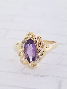 Vintage Amethyst & Diamond ring. This ring features a marquise shaped Amethyst and two diamonds on each side. Details: Size: US 6 1/4 ( Can be sized ) Weight: 3.5 grams Primary stone: Amethyst Stone Shape: Marquise ( Appx. 1.0 tcw. ) Secondary Stone: Diamond Stone Shape: Round ( Appx. 0.06 tcw. ) Metal: 14k Yellow Gold Condition: Brand new Inside of band is stamped and tested for '14k' gold. SIZING: Currently this ring is a size 6 1/4 but could be sized up or down for an additional small fee Formal Marquise Birthstone Ring, Elegant Purple Amethyst Ring With Marquise Cut, Elegant Purple Marquise Cut Amethyst Ring, Purple Marquise Jewelry For Formal Occasions, Marquise Birthstone Ring In Fine Jewelry Style, Marquise Gemstone Accented Formal Jewelry, Gold Marquise Amethyst Ring, Fine Jewelry 14k Gold Marquise Amethyst Ring, Marquise Amethyst Ring In 14k Gold