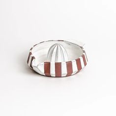 a white and red striped bowl on a white surface with a black stripe around it